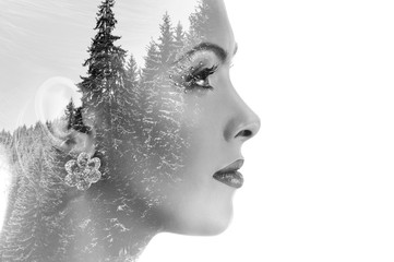 Double exposure of beautiful woman and trees covered with snow