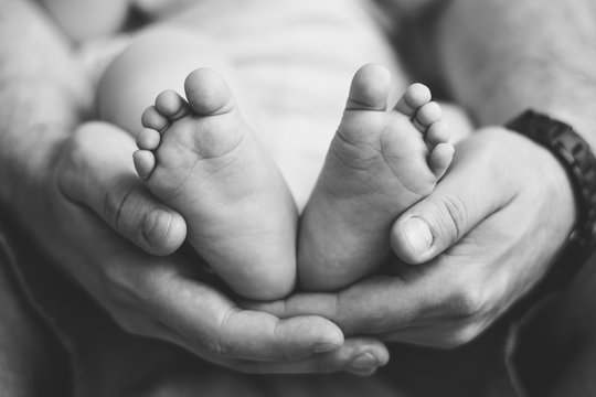 Close-up of a fathers holding his baby feet