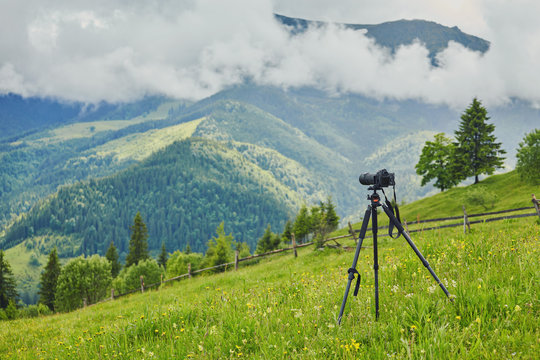 Fototapeta Dslr digital professional camera stand on tripod photographing mountain, Blue sky and cloud landscape.