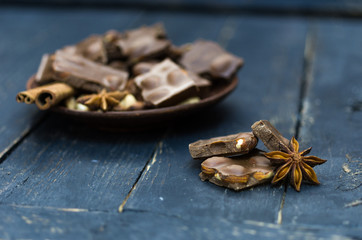 Chunks of chocolate and nuts in a plate. Front view.