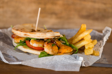Healthy veggie panini sandwiches, Freshly grilled panini with shrimps, olives, basil leaves, fresh red and green peppers, tomatoes, and mozzarella cheese served on ciabatta bread 
