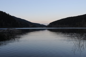 Beautiful twilight reflection in a mountain lake panorama, Oker dam in National Park Harz in Northern Germany