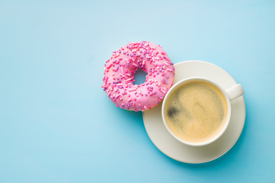 Pink donut and coffee cup.