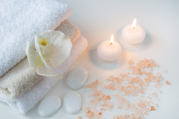 Fototapeta na wymiar on a white table objects of Spa: towels, salt, candles and stones