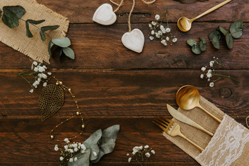 Wedding concept. Rustic table set with decorations over wooden background. Boho style, top view, flat lay