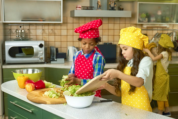 Kids cooking at kitchen table. Fruit and vegetables.