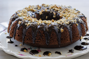 Chocolate cake, sliced, covered with coconut and walnut.