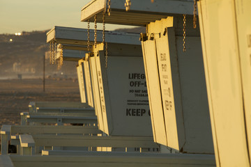 Closed lifeguards stands lined up next to each other on the beach in the winter