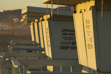 Closed lifeguards stands lined up next to each other on the beach in the winter