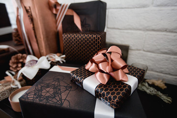 Presents wrapped in black and copper paper with copper colored bows. 