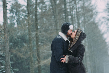 guy and girl walking and having fun in the snowy forest