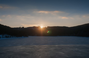 Sunset at a frozen mountain lake, Oker dam in National Park Harz, Northern Germany