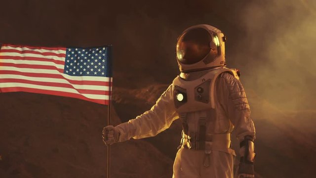 Astronaut Wearing Space Suit Plants American Flag on the Planet Mars. Patriotic and Proud Moment for the Whole of Humanity. Shot on RED EPIC-W 8K Helium Cinema Camera.