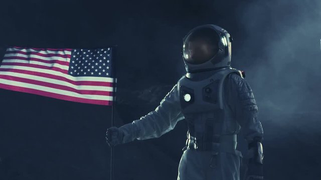 Strong Astronaut Walks Through the Storm with a Flag of Unites States of America, Proudly Pants it on the Dark Alien Planet. Space Travel, Colonisation Theme. 