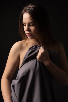 Portrait of a beautiful young sexy brunette girl on a black background.