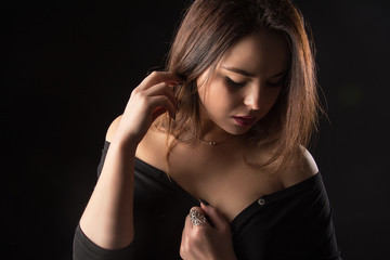 Portrait of a beautiful young sexy brunette girl on a black background.