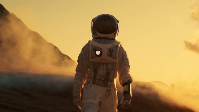 Astronaut Confidently Walking on Mars. Red Planet Covered in Rocks, Gas and Smoke. Humans Overcoming Difficulties. Big Moment for the Human Race. Shot on RED EPIC-W 8K Helium Cinema Camera.