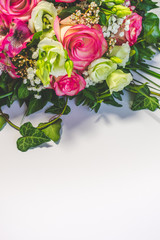 Close up view of a bunch or a bouquet of pink roses, pink Alstroemeria and white Lisianthus flowers  on a white background with copy space