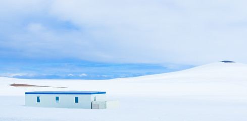 white snow covered mountain and a solo building iceland