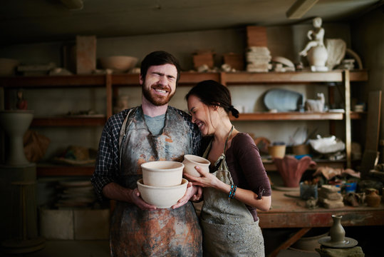 Happy potters family posing in small workshop