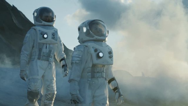 Two Astronauts in Space Suits Walking on Alien Planet. 