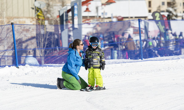 Ski Instructor Teaching a 3-Year Old Toddler Boy at a Mountain Resort