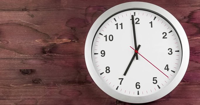 it's seven o'clock already, time to wake up for breakfast, modern white metallic alarm wall clock on dark wood background