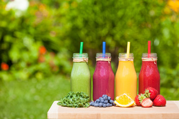 Fototapeta na wymiar Assortment of healthy bottled juce smoothies, kale, blueberry, orange, strawberry.