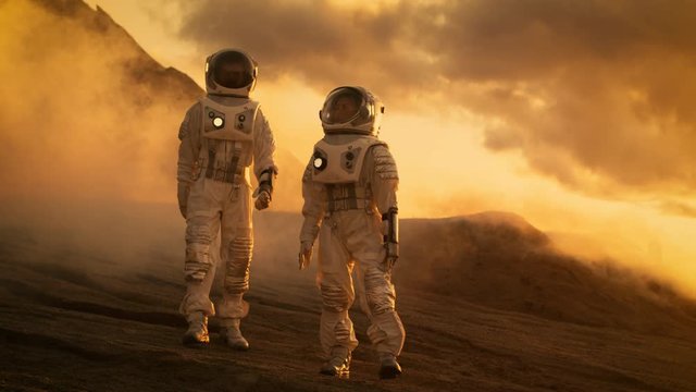 Two Astronauts in Space Suits Confidently Walking on Mars, Exploration Expedition on the Planet's Surface. Space Travel, Planet Discovery, Colonization Concept. 