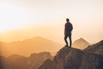 Hiker on a desert mountain summit at sunset