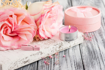 Obraz na płótnie Canvas Pink gift box, roses, lit candle