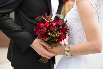 Beautiful wedding bouquet of flowers in hands of the bride