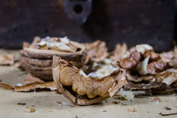 Walnuts on a wooden kitchen table. Nuts and a black wooden crate with a nutcracker.