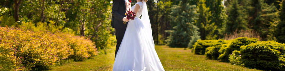 Beautiful wedding couple in park. They hug each other