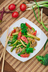 Salad with mushrooms, avocado, tomatoes and greens. Wooden rustic background. Top view