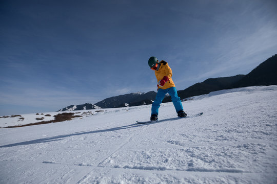 one snowboard snowboarding descent on slope in ski resort