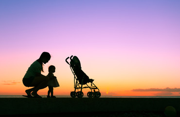 Mother enjoying the sunset with her little girl. Parenting, and child care concept. 