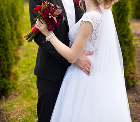 Beautiful wedding bouquet of flowers in hands of the bride
