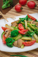 Salad with mushrooms, avocado, tomatoes and greens. Wooden rustic background. Top view