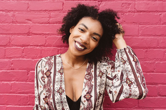 A Young African American Woman Standing Against A Colorful Wall In The City