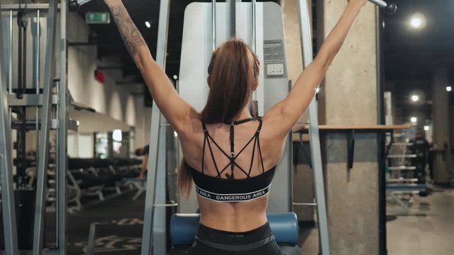 Sexy athletic sport girl with perfect fitness body doing workout hard training with bar on incline bench in the gym, professional athlete muscle fit serious girl