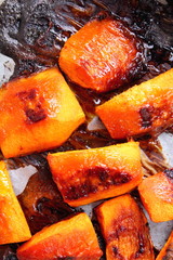 Pumpkin, oven-baked pumpkin, homemade food, vegan food, healthy food, orange pumpkin with honey, orange vegetables on a roasting pan, baked rustic vegetables, pop art, dessert during a diet