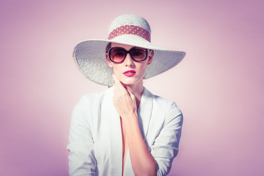 Fashion style portrait of woman wearing hat and sunglasses. Studio shoot. 