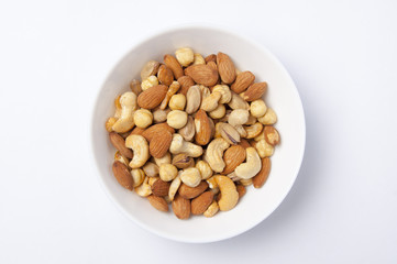 Çerez tabağının içinde fındık, fıstık, antep fıstığı, badem ve kaju, beyaz izole edilmiş arka plan,
