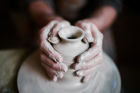 Potter shaping beautiful clay vase on wheel