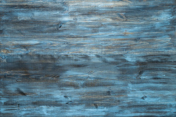 Blue stained wood texture background with a worn distressed effect. Use this weathered wooden textured material as design asset for a wall, floor boards, wallpaper, table surface or abstract backdrop.