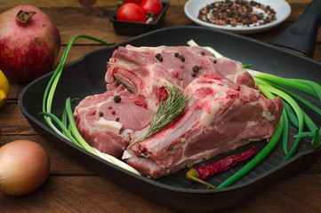 Ingredients for cooking rib eye roast beef steak on black iron grilling pan. Wooden rustic background. Top view, horizontal composition