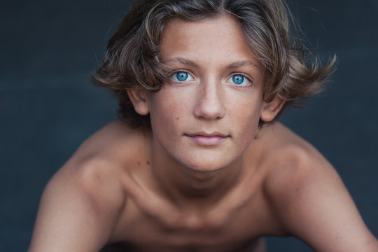 Bare chested blue-eyed teen portrait in summer