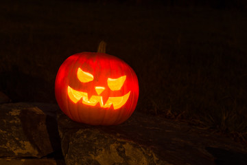 Spooky Halloween Pumpkin in the Dark night on a stone wall