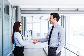 Young colleagues shake hands after a successful job